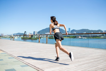 Back view of woman running in seaside boardwalk