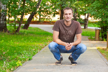 Obraz premium Portrait of a happy smiling young man in a city park