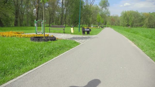 Girl riding a roller skates. She is waving to sameone. Slow motion.
