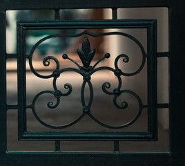 Details, structure and ornament of iron gate. Vintage decorative ornament, made from metal. Decorative elements as a background. Floral pattern, toned image cinematic look