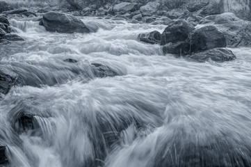 River water flowing through rocks at dawn