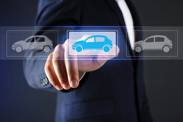Businessman touching icon of car on virtual screen