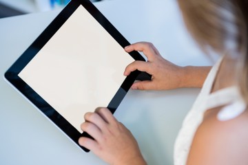 Cropped image of girl using digital tablet in library