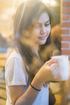 Attractive female Asian university student drinking coffee in co