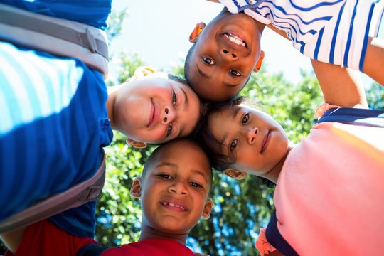 Portrait Of Happy Children Forming Huddle