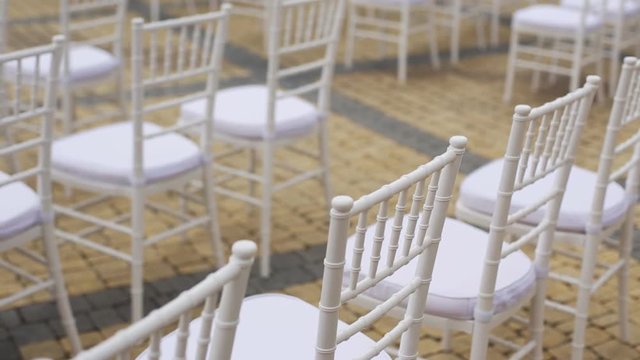 Dolly of rows of chairs at a wedding ceremony from the aisle and from the back