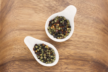 Different kind of pepper on wood background