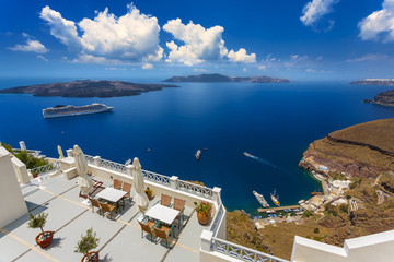 Greece. Cyclades Islands - Santorini (Thira). Fira town (the modern capital of island) with characteristic style for Cycladic architecture. There are islands: Nea Kameni and Thirasia in the background