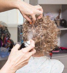 Naklejka premium Female hair lacquer in a beauty salon