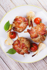 Pork rolls with cherry tomatoes and garlic. View from above, top studio shot