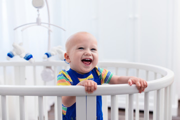 Baby boy standing in bed