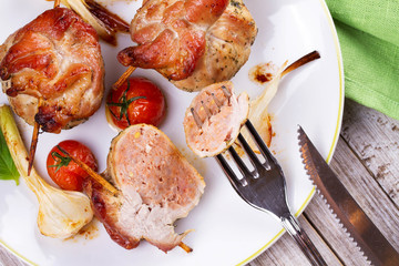 Pork rolls with cherry tomatoes and garlic. View from above, top studio shot