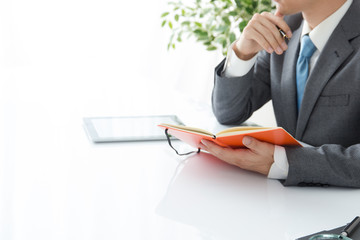 手帳を見る男性サラリーマン