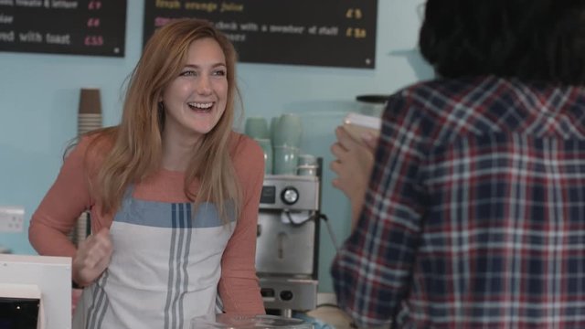 Female barista in cafe serving coffee