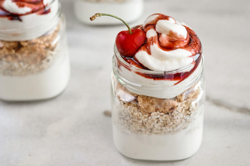 Yogurt with muesli and strawberry on a wooden table