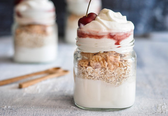 Yogurt with muesli and strawberry on a wooden table