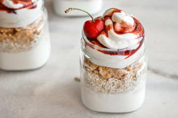 Yogurt with muesli and strawberry on a wooden table