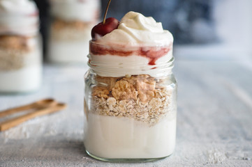 Yogurt with muesli and strawberry on a wooden table