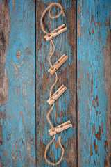 Clothespins with a rope on blue wooden boards