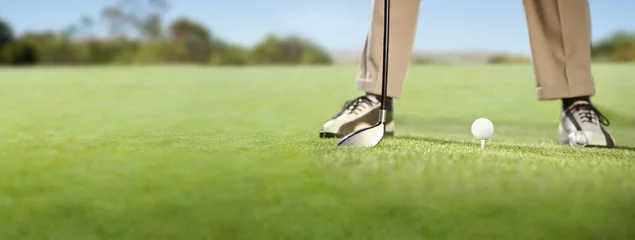Tableaux ronds sur aluminium brossé Golf Golfer placing golf ball on tee