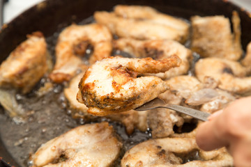 fish is fried in a pan in butter
