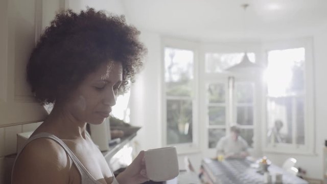 Afro American woman in kitchen enjoying coffee in the morning