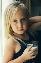 5 years old girl holding glass of milk