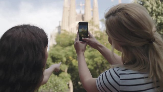 Young adult women taking picture of Cathedral, Barcelona