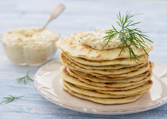 Flat bread with egg dip and dill on a blue wooden background, selective focus