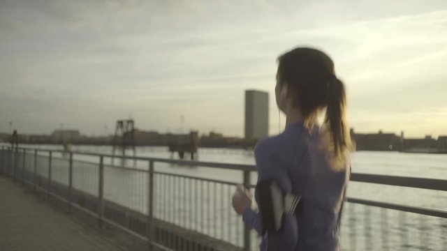 Female runner jogging by river Thames, London