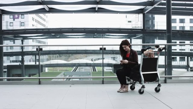 Young Adult Female on smart phone and waiting in airport