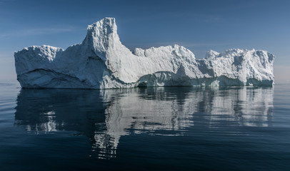 Fototapeta na wymiar Iceberg reflecting in the water at Isfjeldbanken near Ilulissat, Disko Bay, West Greenland