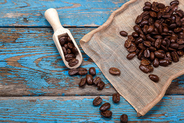 Coffee beans with a wooden scoop.