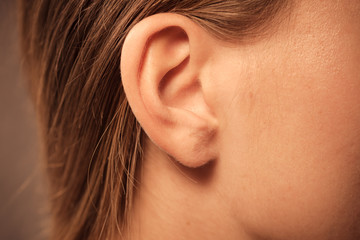 Close up on female ear - obrazy, fototapety, plakaty