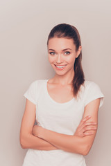 Young girl with beaming smile posing with crossed hands