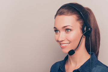 Pretty smiling secretary  in headphones isolated on gray backgro