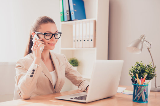 Smart pretty businesswoman in glasses talking on phone with clie