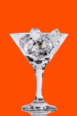 Ice cubes in martini glass on color background