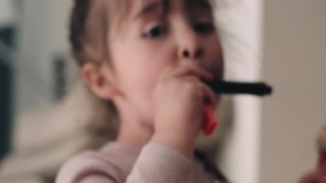 Girl playing harmonica with sister 