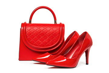 Red female leather shoes and red leather bag on white background
