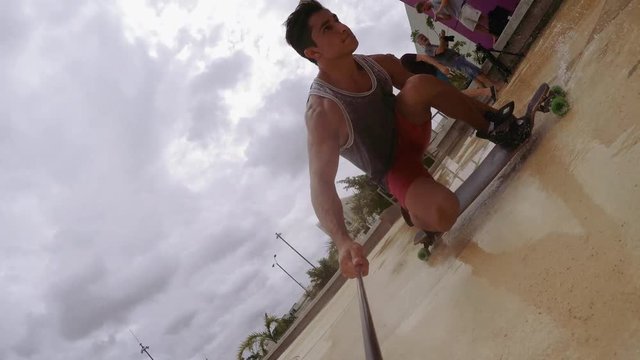 Man holding monopod and enjoying skateboarding at street