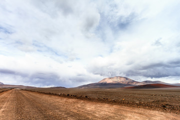 Dirt road on the Andes mountains (Chile) with San Francisco volcano 