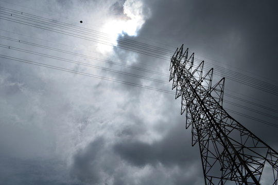 Silhouette of electricity post in cloudy sky,low angle shot.high voltage electric pole,high voltage power supply,high voltage power line.