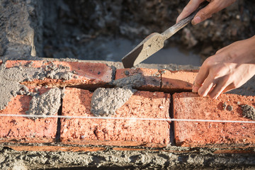 plasterer making up a brick wall with cement