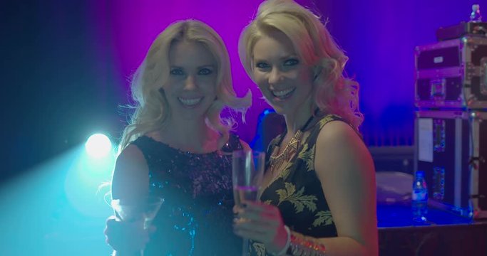 Female friends having fun with champagne in nightclub