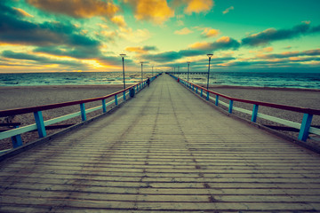 Perspective view of wooden pier over sea. Palanga city at sunset in autumn, Lithuania