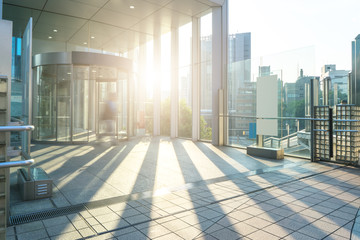 Fototapeta na wymiar empty footpath through modern office buildings in tokyo with sun