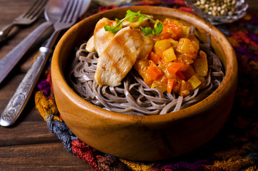 Dark pasta with vegetables and chicken.