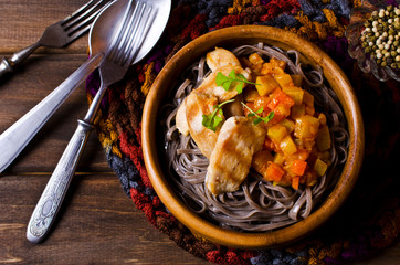 Dark pasta with vegetables and chicken.