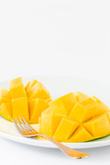 Delicious mango on white plate with a fork